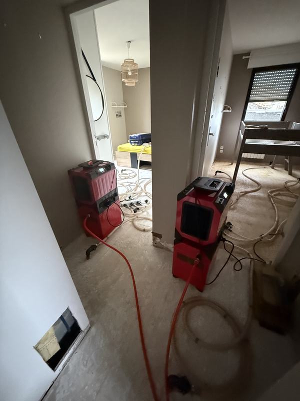 Deux déshumidificateurs Corroventa installés de part et d'autre d'un couloir dans un logement en cours d'assèchement